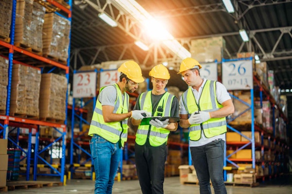 men in PPE inside a warehouse