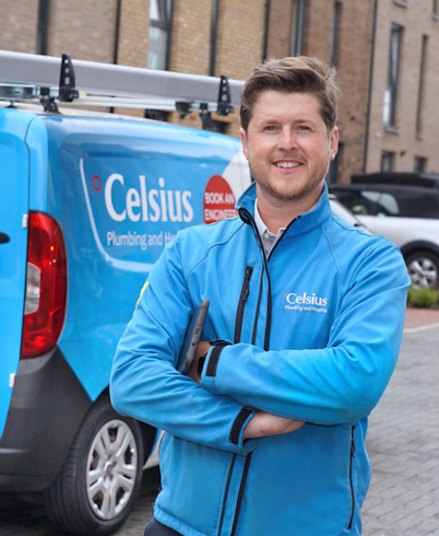 A man wearing a blue fleece, standing in front of a van that says Celsius