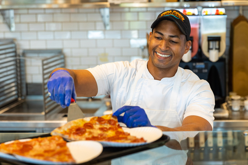 Chef serving pizza at Pizza Ponte