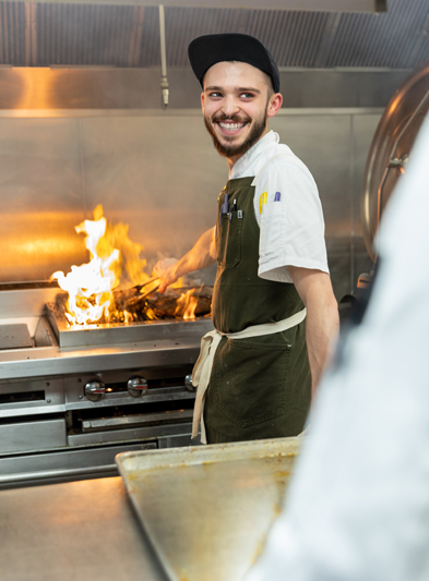 Smiling employee working on the grill.