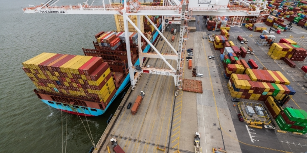 A huge crane loads containers onto a cargo ship at the Port of Baltimore. 