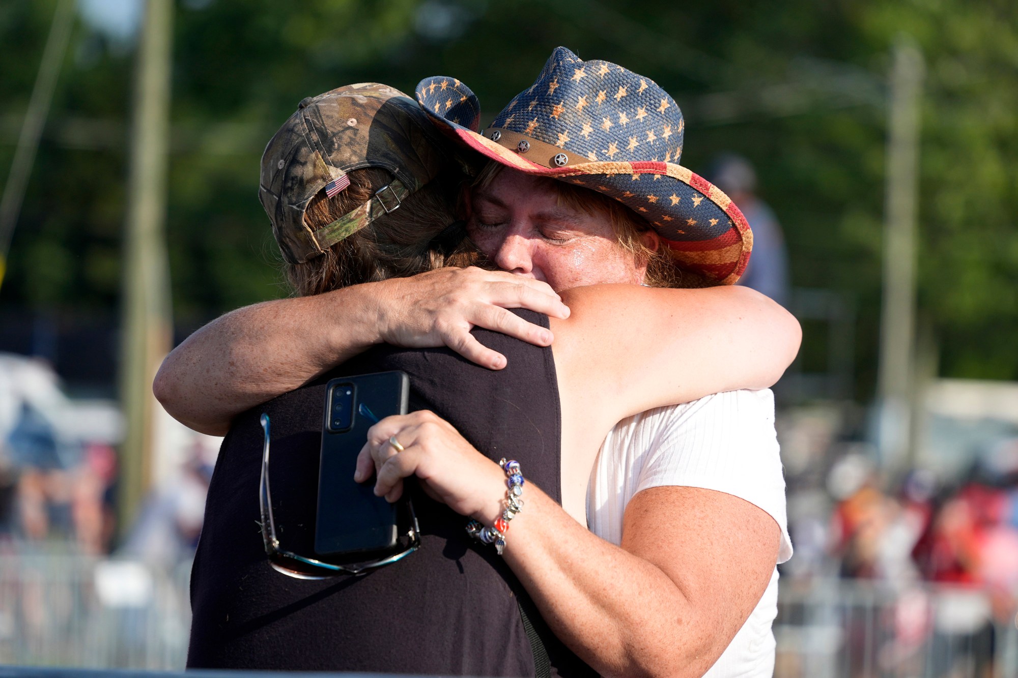 People hug after Republican presidential candidate former President Donald Trump was helped off the stage at a campaign event in Butler, Pa., Saturday, July 13, 2024. (AP Photo/Gene J. Puskar)