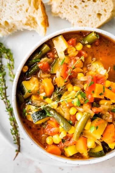 An overhead view of a bowl of vegetable soup.