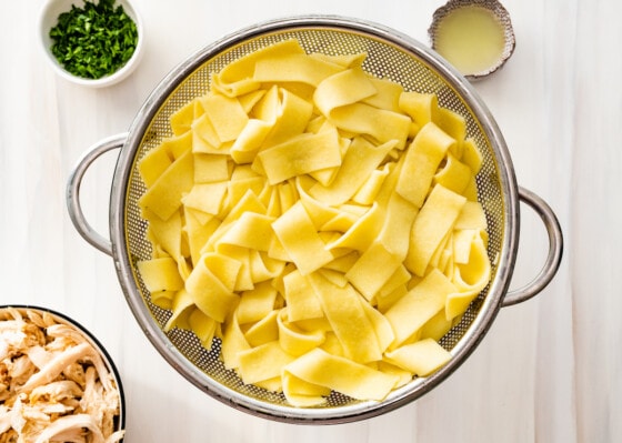 Large noodles in a metal strainer.