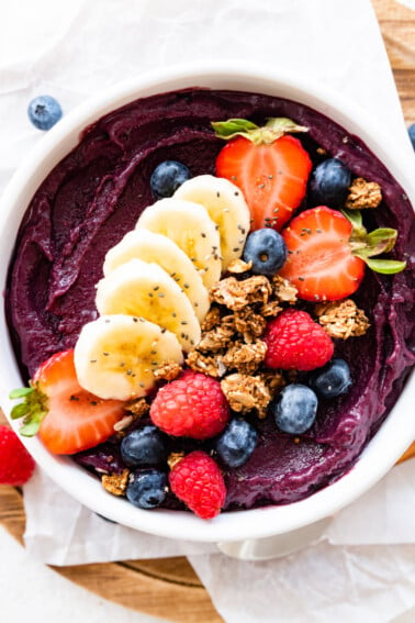 An acai bowl topped with fresh berries, sliced banana, and granola.