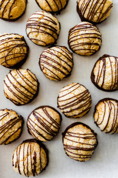 Multiple coconut macaroons near one another on parchment paper.