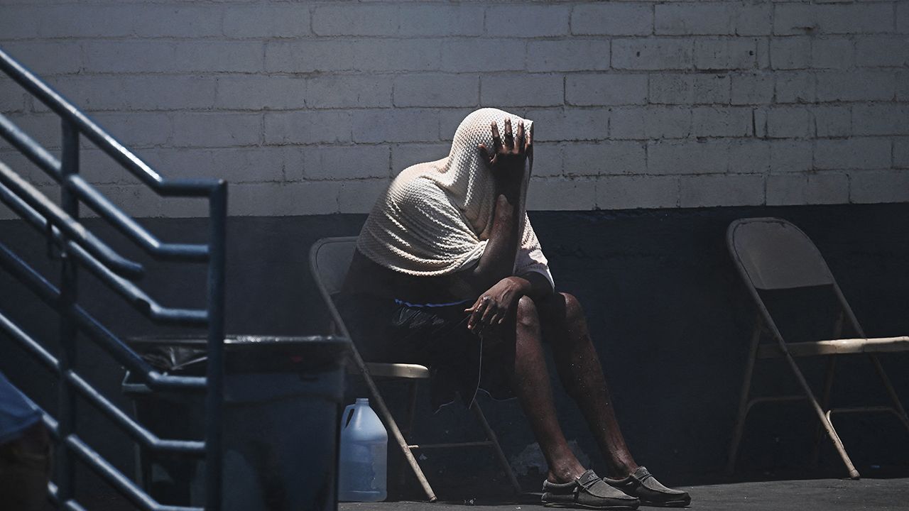 A person covers their head while trying to stay cool in a homeless encampment, during a record heatwave in Phoenix, Arizona 