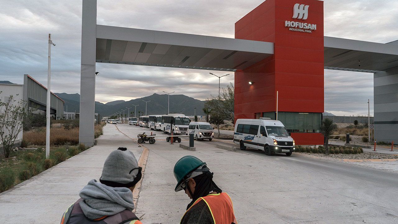 Workers wait for a taxi outside of the Hofusan industrial park, in Nuevo León, Mexico.