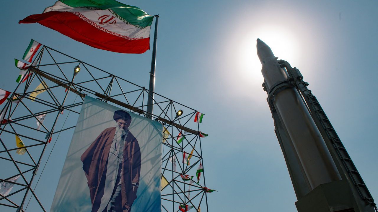 A big banner depicting Iran's Supreme Leader Ayatollah Ali Khamenei is placed next to a ballistic missile in Baharestan Square in Tehran