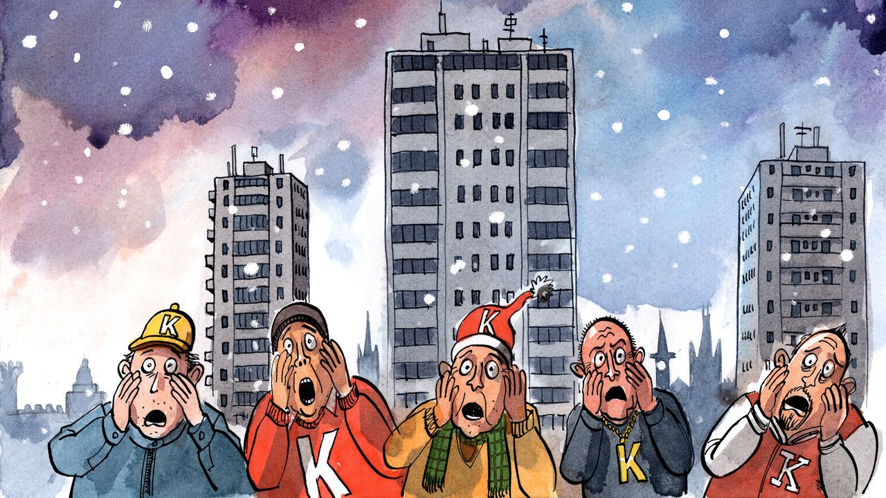 A row of males, all with the letter 'K' on either their jumper or hat, stand in front of a cityscape looking horrified.