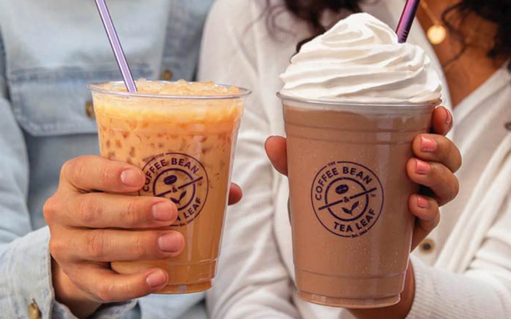 Two ladies clinking two cups of coffee