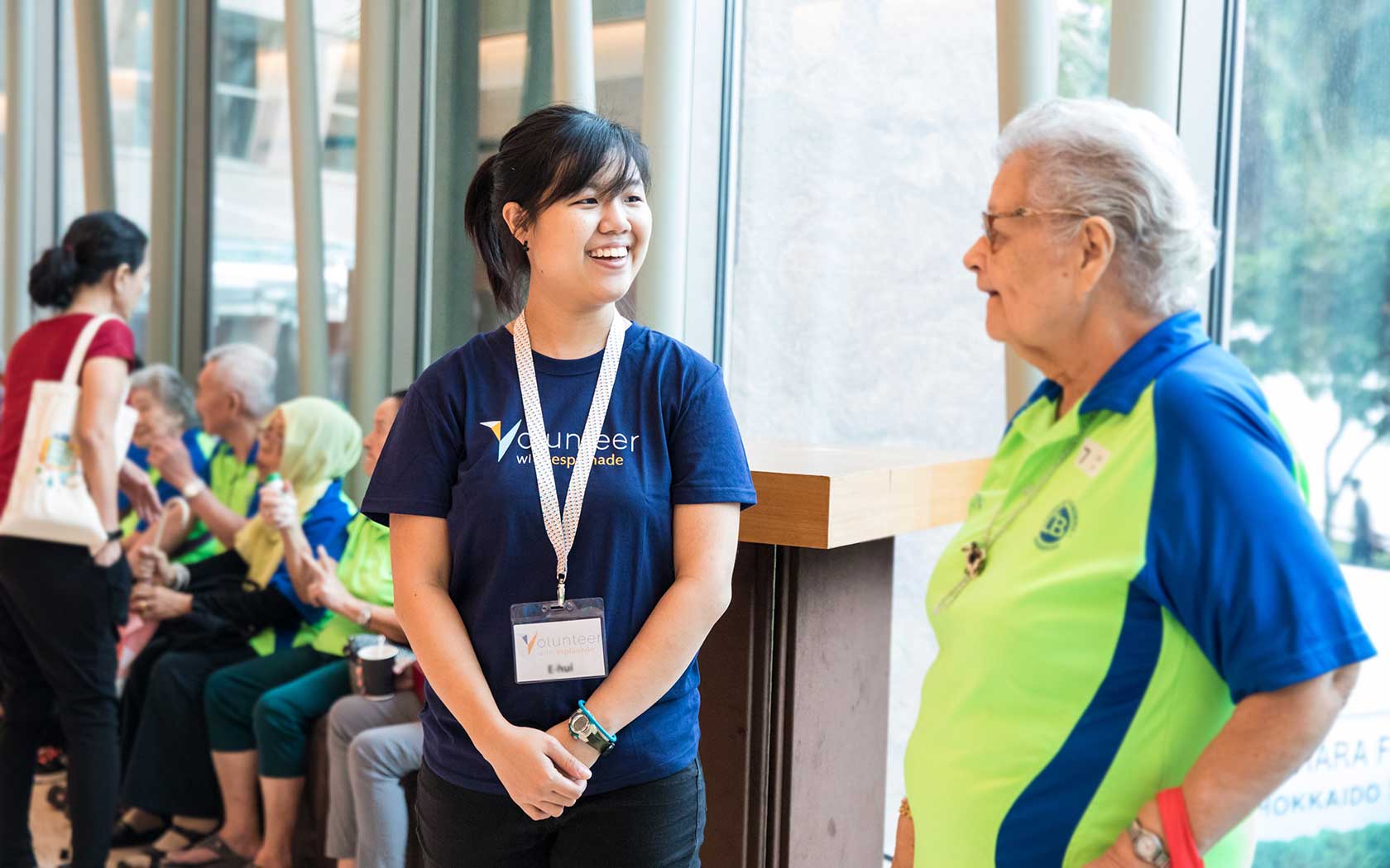 Image of volunteer talking to an elderly patron at Esplanade