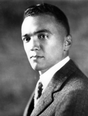 A young J. Edgar hoover. He has short hair and is wearing a suit. 