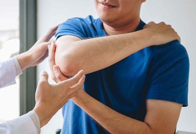 Doctor treating a patient who has a hyperextended elbow