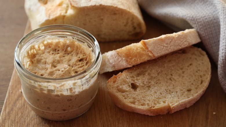 Sourdough starter with bread on wood board