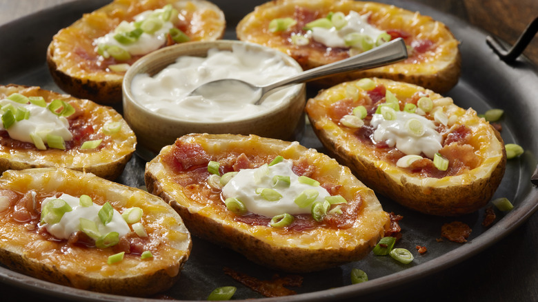 plate of potato skins with sour cream in middle