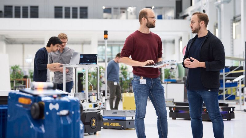 zwei Mitarbeiter von ARENA2036 in der Werkshalle im Gespräch