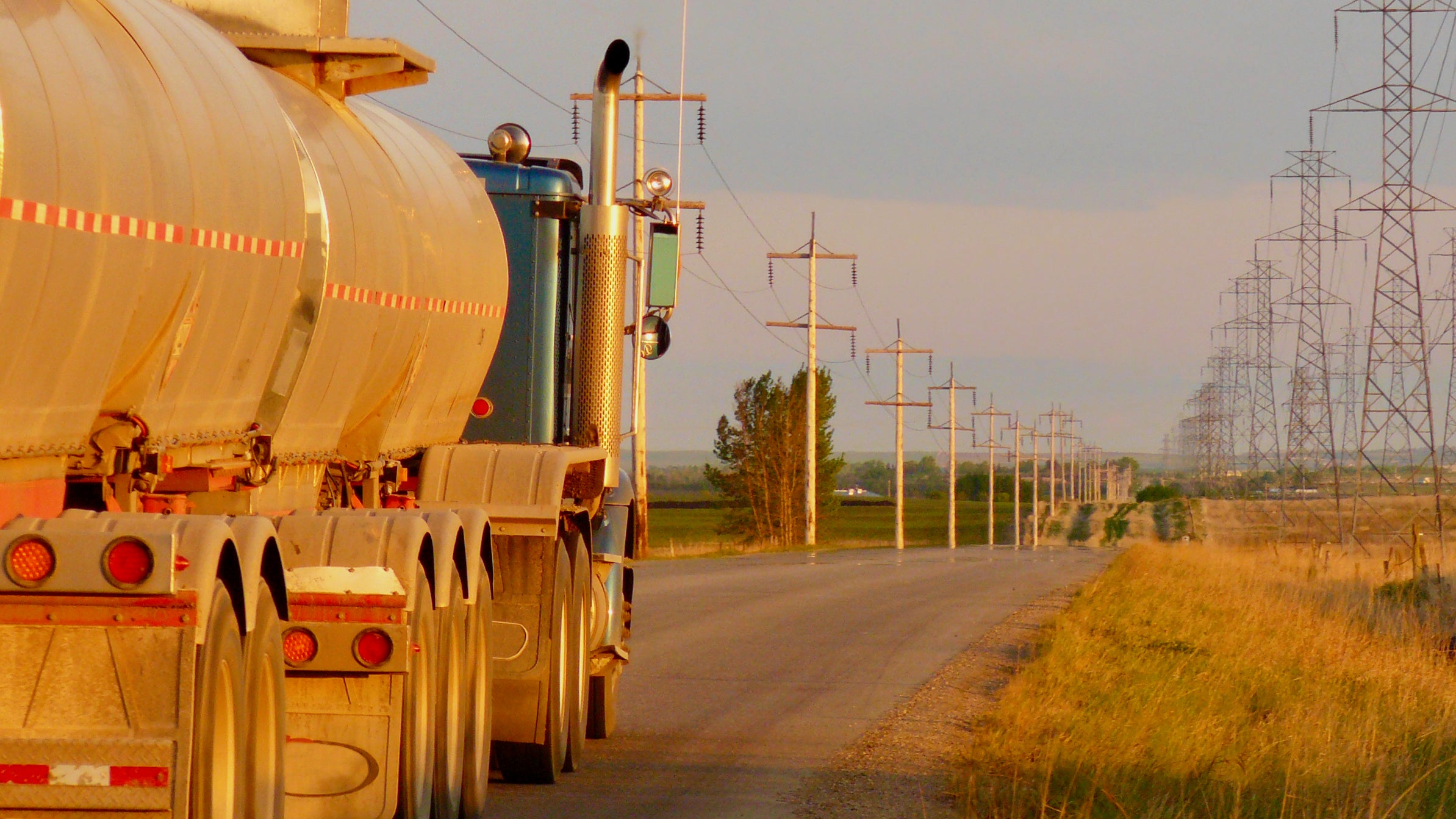 A truck with a tank trailer travels on a road in Alberta.