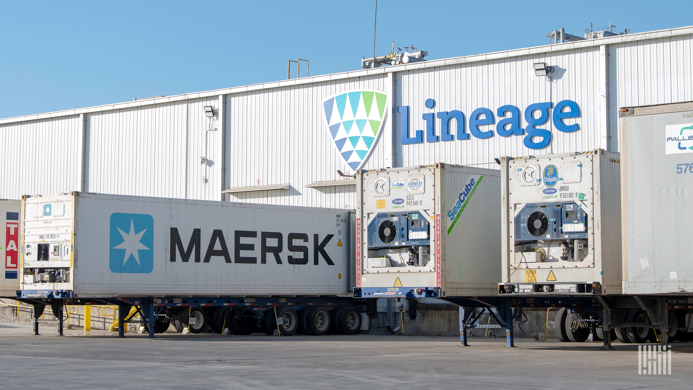 Trailers are docked at a warehouse facility with the name Lineage written on it.