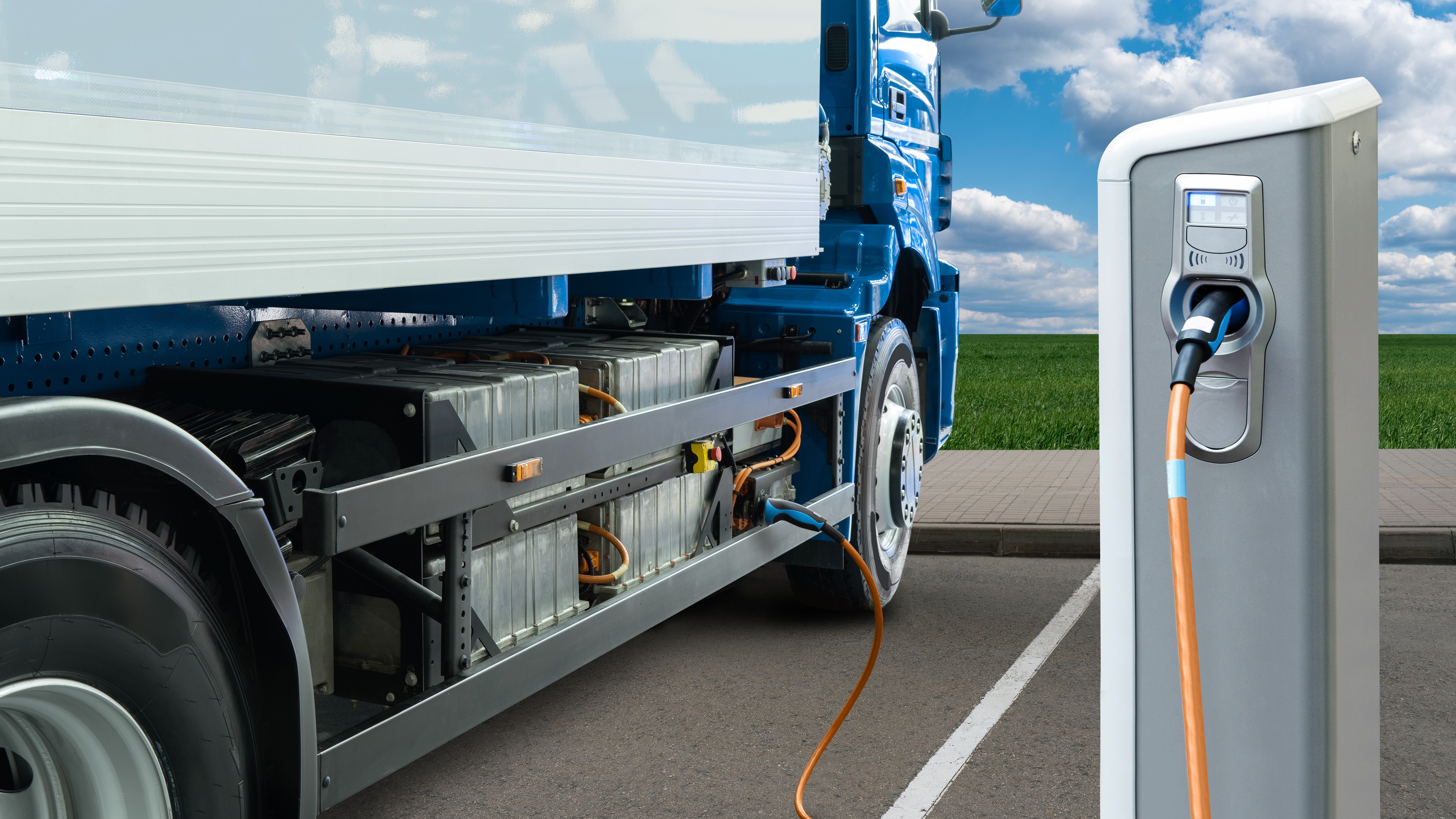 An electric truck is parked by a charging station.