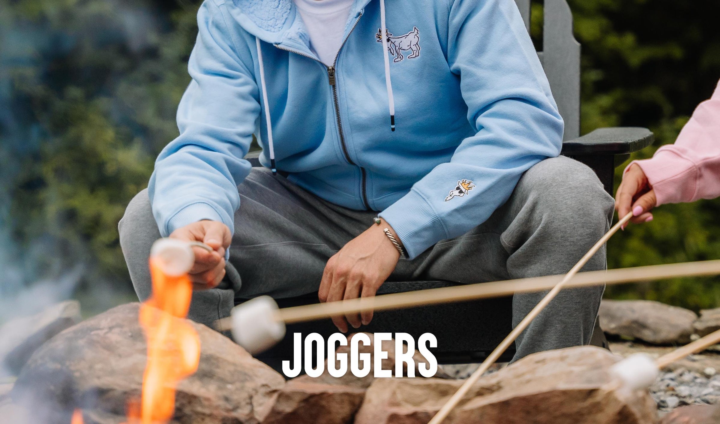 Shot of two people's pants while they are roasting marshmallows