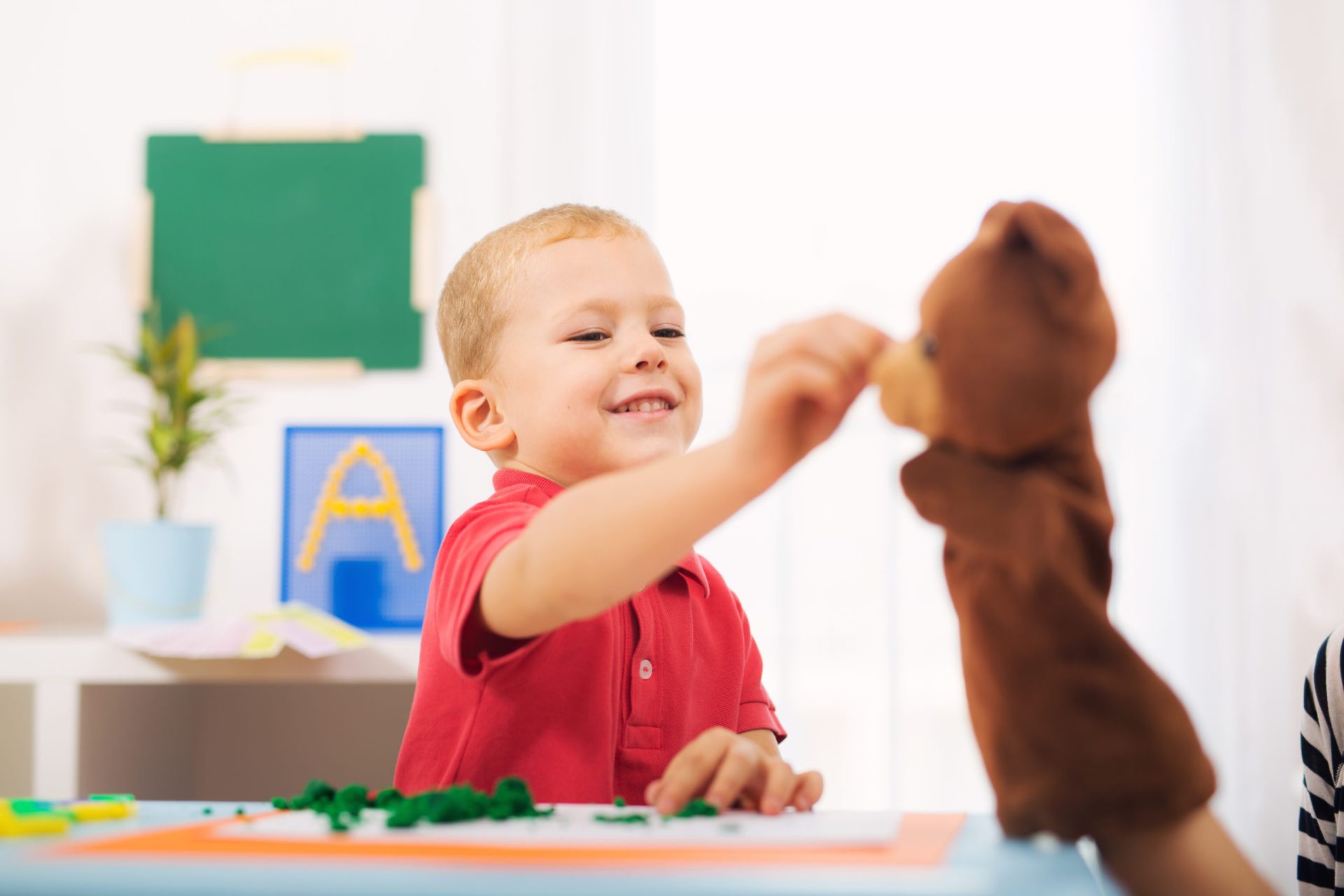 Little boy during lesson with his speech therapist.