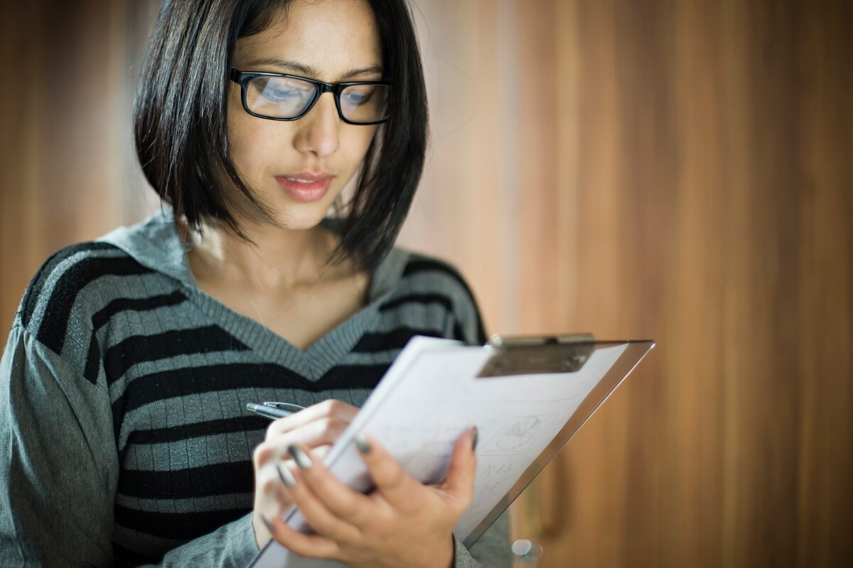 Therapist checking items off list on clipboard