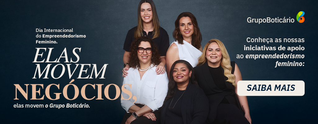 Na imagem do banner, em um fundo preto, iluminado no centro, temos cinco mulheres lado a lado, sorrindo e posando para a câmera. Da esquerda para a direita, a primeira mulher está em pé. Ela é branca de olhos castanho-escuros e cabelos lisos e castanhos, veste uma camiseta preta e usa um relógio preto no punho esquerdo. Na frente dela, temos a segunda mulher, que está sentada. Ela é uma mulher madura, branca, de olhos castanho-escuros e cabelos encaracolados pretos, na altura dos ombros. Ela veste uma camisa branca e uma calça preta, usa um colar de pérolas brancas, um relógio no punho esquerdo e óculos de grau de armação marrom. Em pé, ao lado da primeira mulher, temos a terceira. Ela é branca de olhos e cabelos castanho-escuros. Ela veste uma regata branca de um ombro só. Na frente dela, sentada, temos a quarta mulher. Ela é negra de olhos castanho-escuros e cabelos lisos e pretos. Ela veste uma blusa preta sobreposta por um cardigan preto e usa um colar dourado. Ao lado dela, temos a última. Ela é uma mulher branca de olhos castanho-escuros e cabelos loiros ondulados. Ela veste uma blusa preta sobreposta por um colete preto. À esquerda da imagem, em letras beges e na cor salmão, o texto: “Dia Internacional do Empreendedorismo Feminino. Elas movem negócios, elas movem o Grupo Boticário.”. À direita, em letras beges, os textos: “Conheça as nossas iniciativas de apoio ao empreendedorismo feminino:” e “Saiba mais”. Logo do Grupo Boticário no canto superior direito.