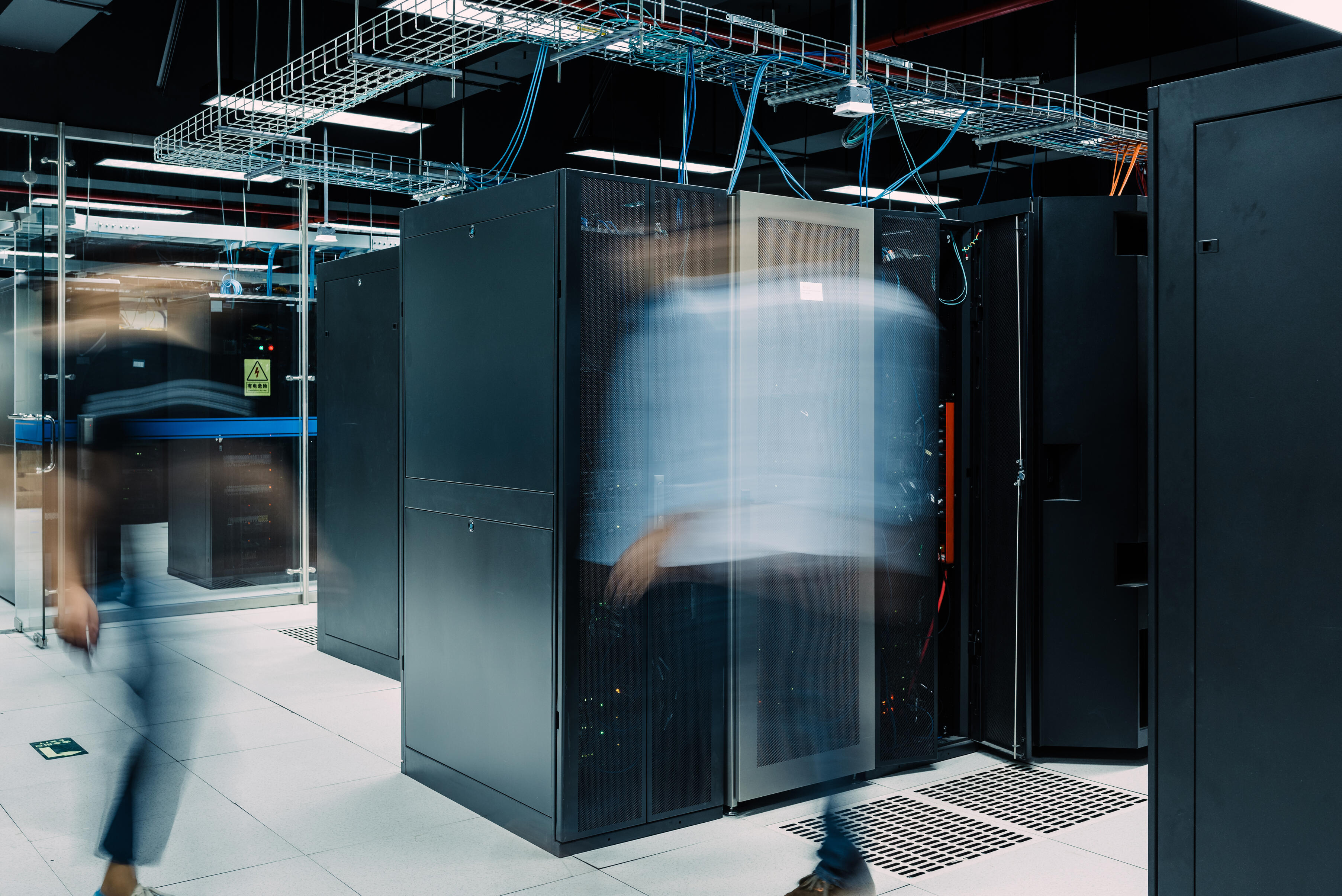 Two blurred individuals in a datacenter