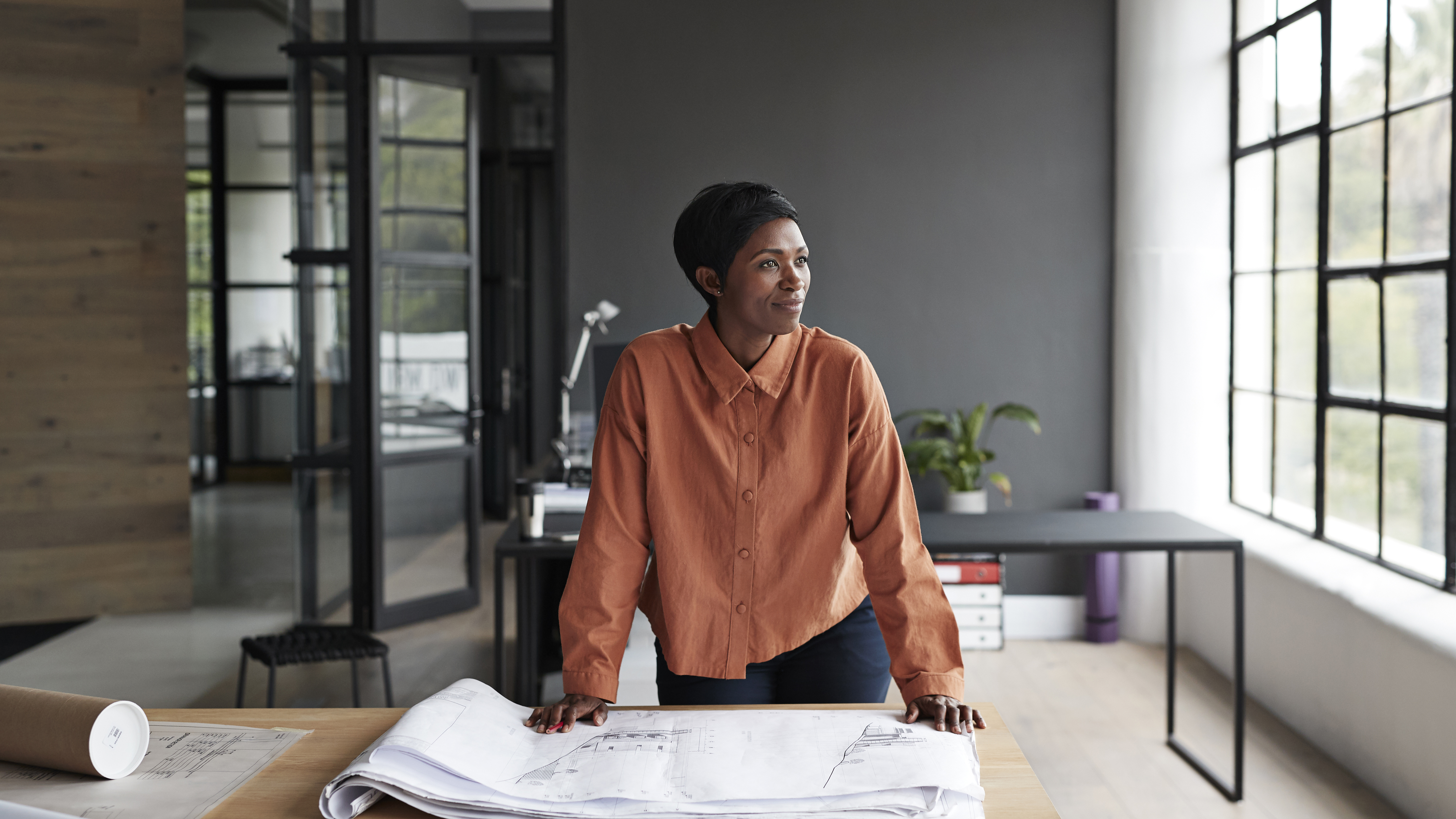 Une personne à l'intérieur d'un bâtiment regardant par la fenêtre