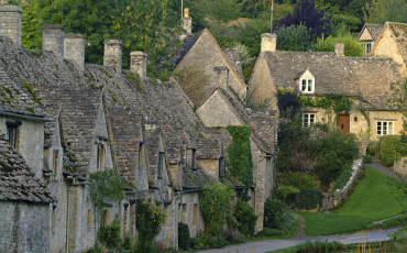 Quaint stone cottages in the Cotswold village of Bibury, Bibury, Gloucestershire, England.