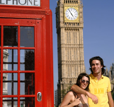 Palace of Westminster - Couple next to a red phone box near Big Ben, enjoying the summer sunshine in England's capital city.