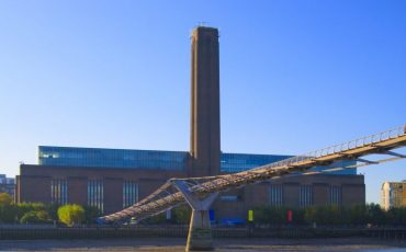 Tate Modern: View from the banks of the Thames River with Millennium Bridge in forefront.