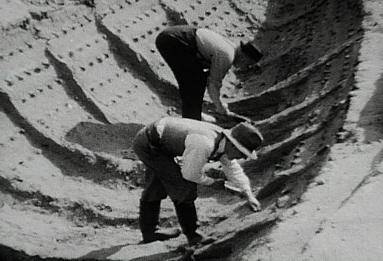 Basil Brown (front) and Lt. Cmdr. J. K. D. Hutchison excavating the 7th-century burial ship at Sutton Hoo in 1939. Photo Credit: © Harold John Phillips via Wikimedia Commons.