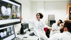 Healthcare worker pointing at medical image on a display screen