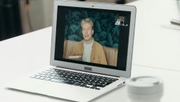 Laptop on a table showing the parties in a video meeting