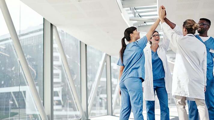 Group of healthcare workers sharing a high-five