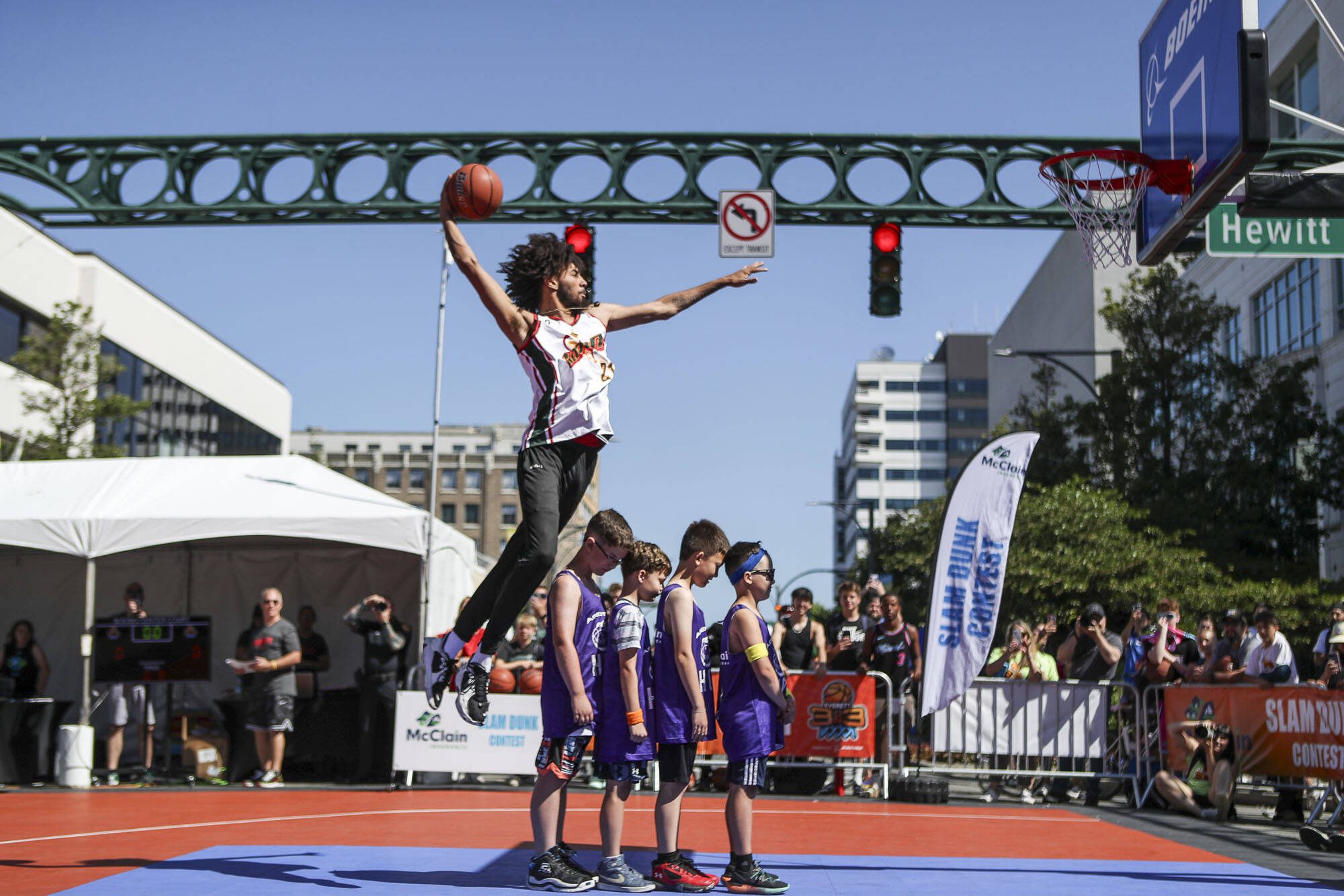 Tyler Cronk performs in the slam dunk competition during the Everett 3on3 tournament in downtown Everett, Washington on Sunday, July 14, 2024. (Annie Barker / The Herald)