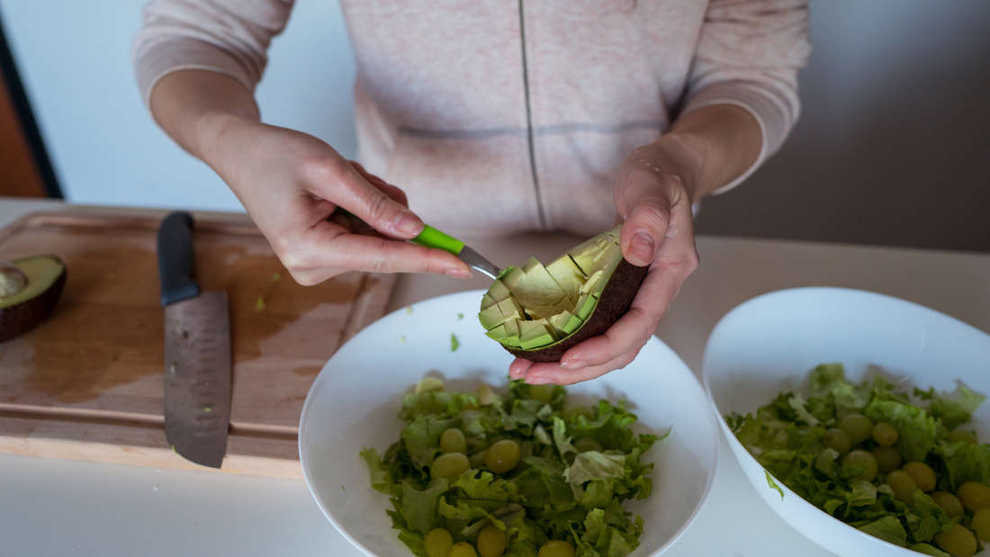 Person bereitet Avocado zu