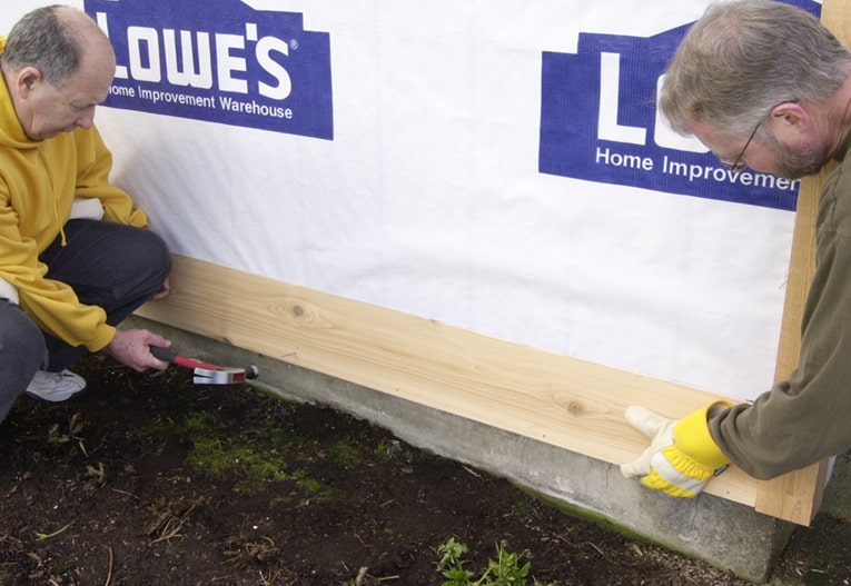 Install the first siding board along the base, overlapping the starter strip.