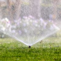 A sprinkler system, an example of an irrigation system, in a yard.