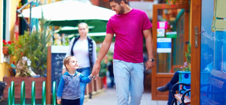 A happy father and son walking the city street settling into a new community.