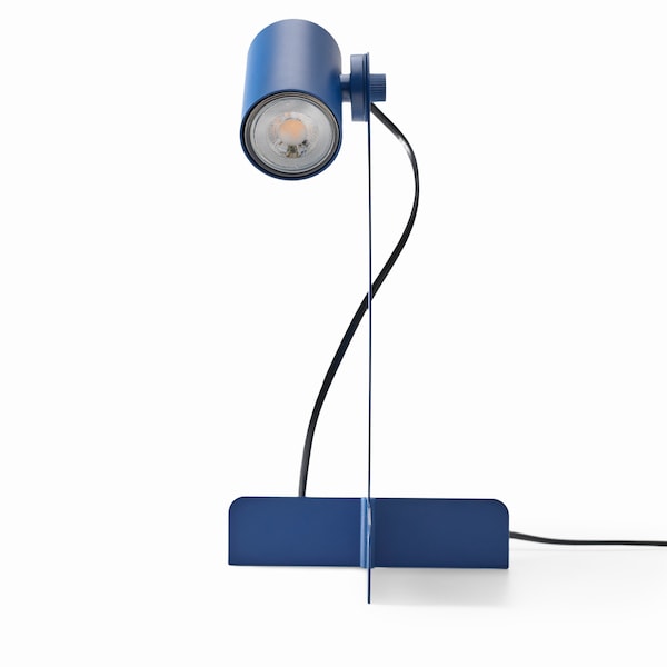 A view of the blue FLOTTILJ desk lamp that shows its slim neck and the placement of the bulb.