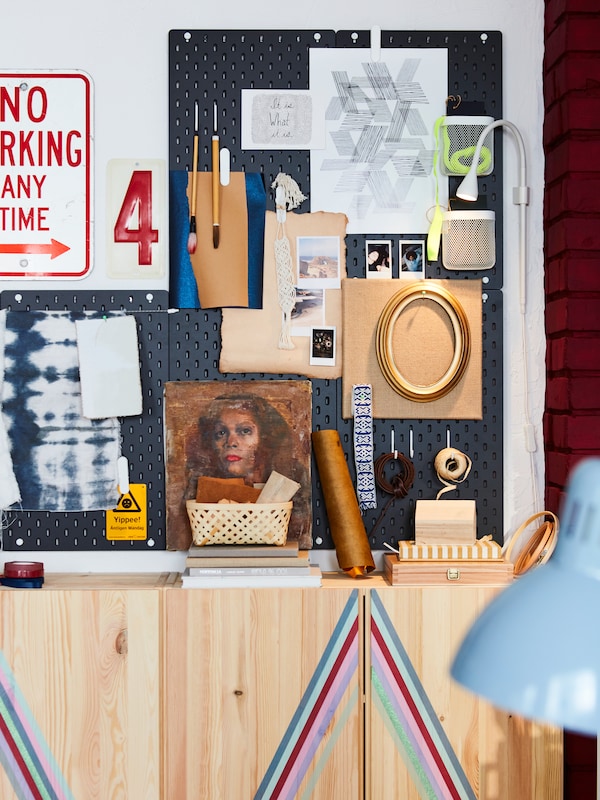 Five SKÅDIS pegboards placed on a wall. These are filled with photos, frames and materials to create an inspiring mood board.