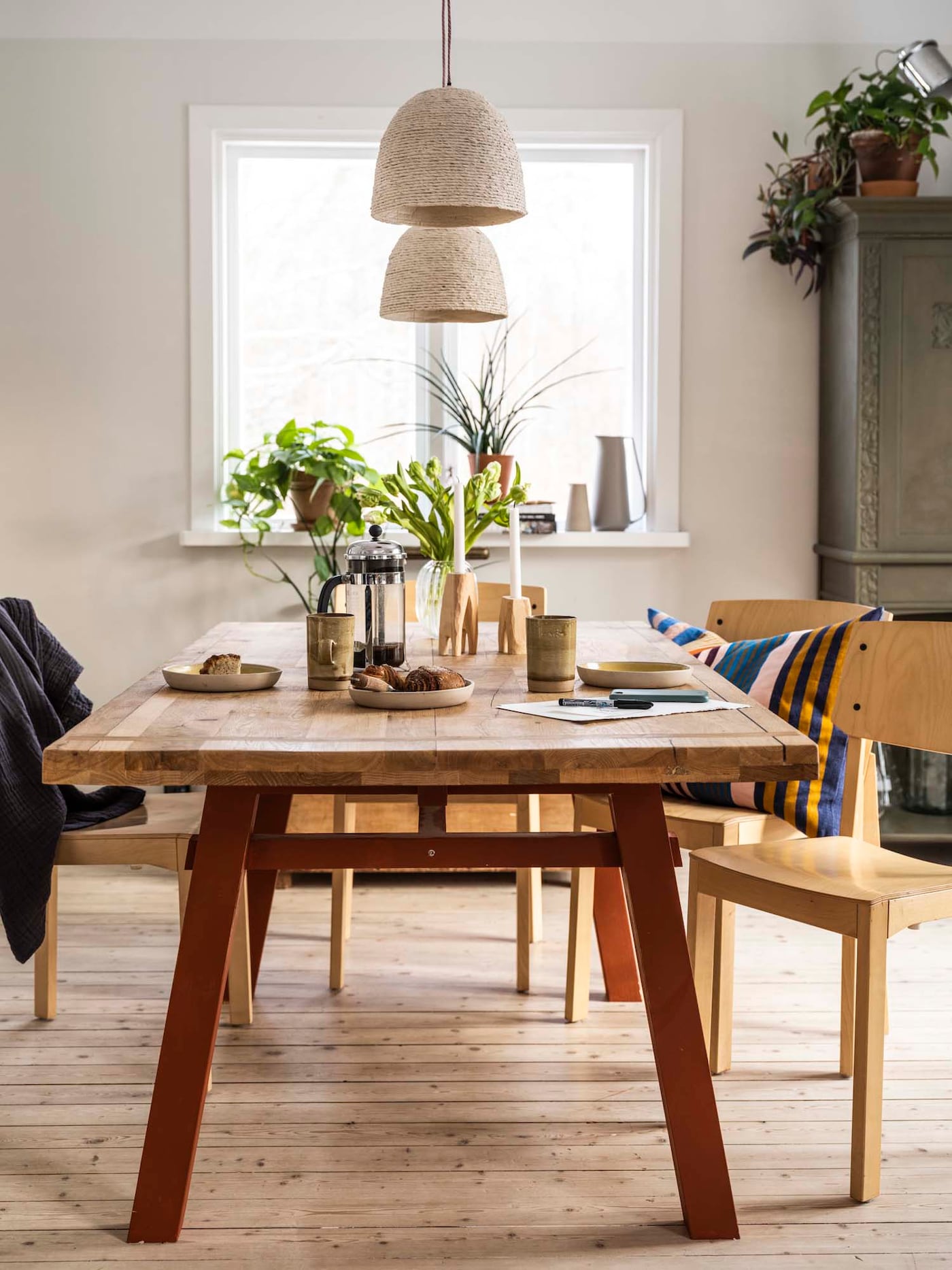 Dining area with a table set with candles, coffee and cinnamon rolls. 