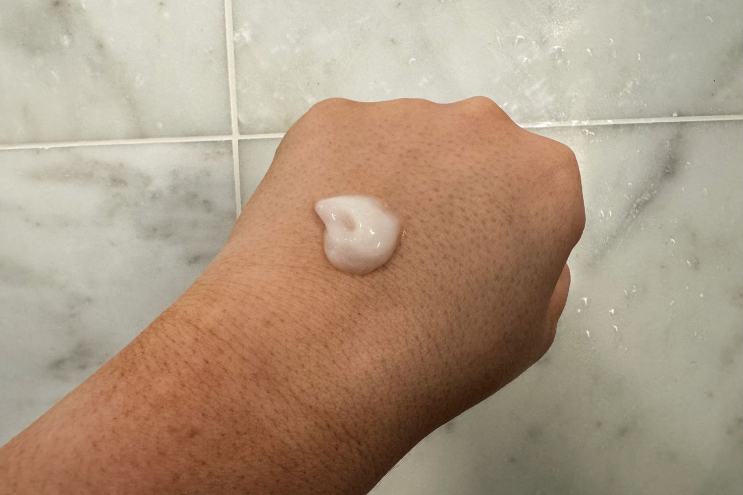 fresh Milk Body Cleanser on the back of a person's hand showing the color and texture