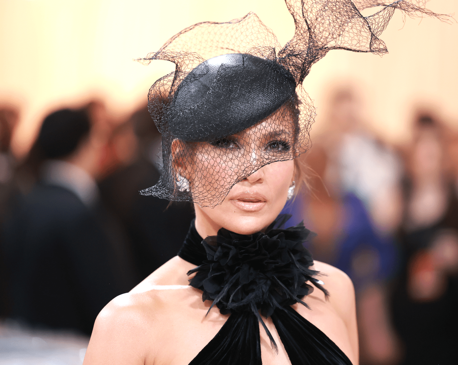 Jennifer Lopez wearing a black hat with a net that covers her face