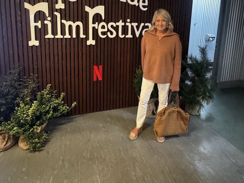 martha stewart in an orange sweater standing in front of the 51st Telluride Film Festival