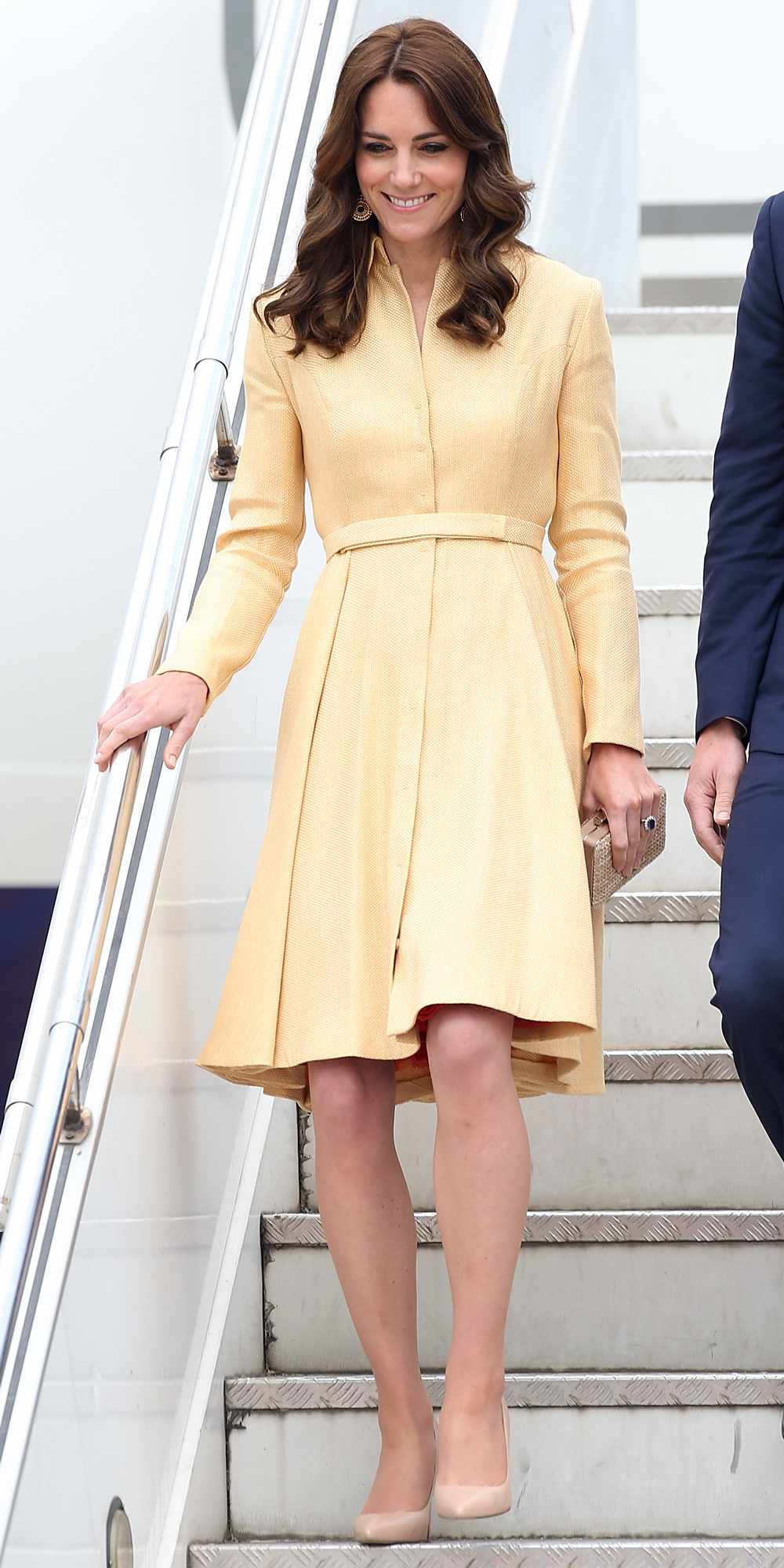 Kate Middleton in a long-sleeve, pale yellow coat dress