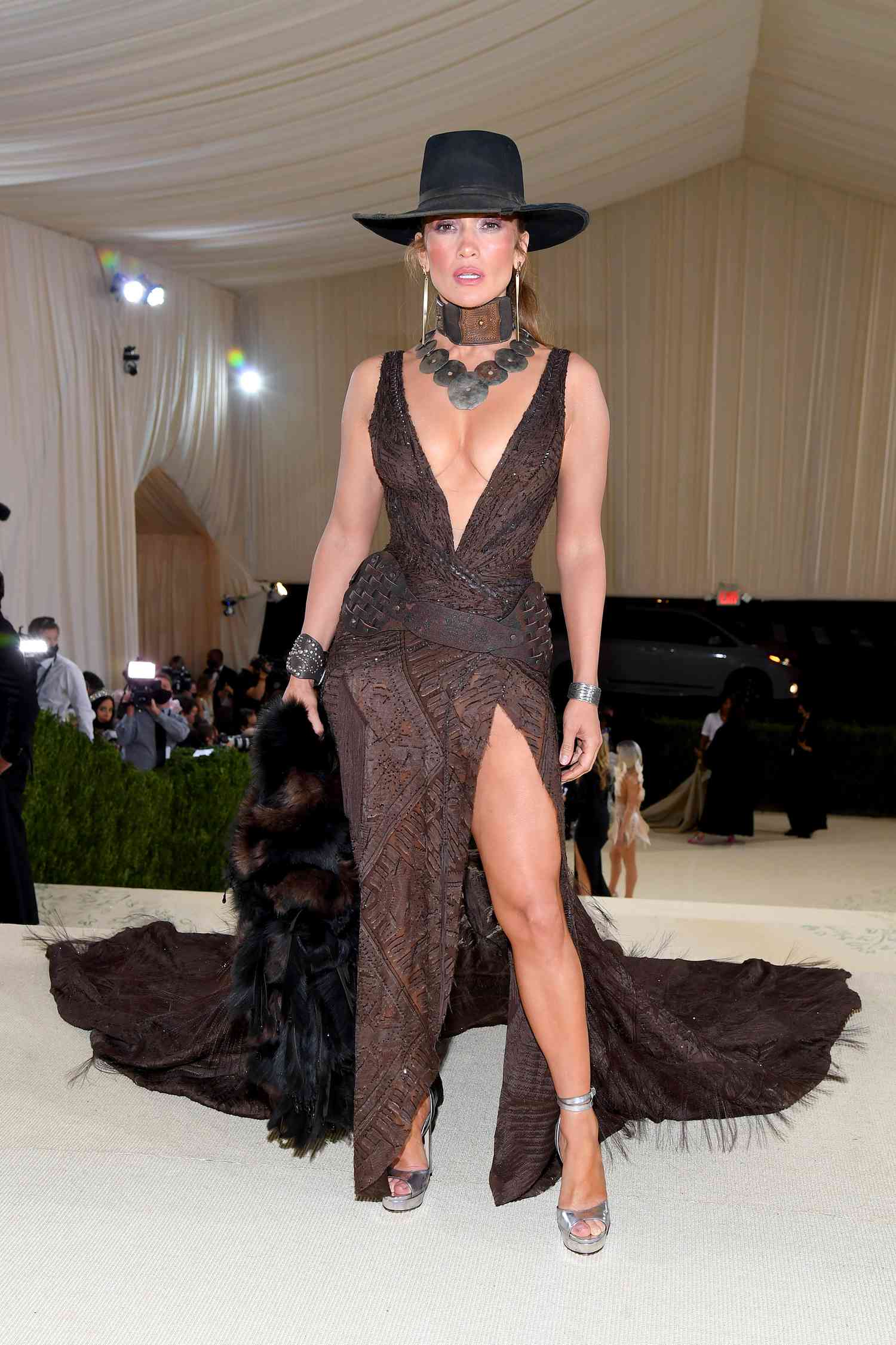 Jennifer Lopez photographed at the Met Gala wearing a brown gown and black hat